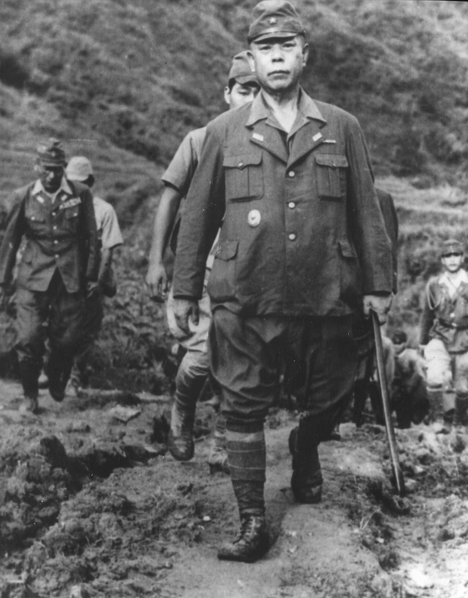 Photo of Japanese officer walking up mountain with others following behind