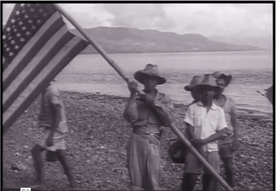 Filipinos stand with a flag on the beach