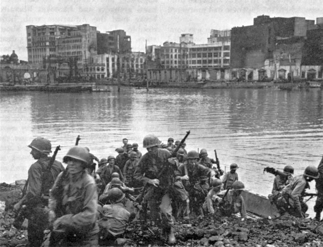 Photo of soldiers disembarking from a small landing craft, running with rifles up the shore onto the beach, silhouetted against the water and sky