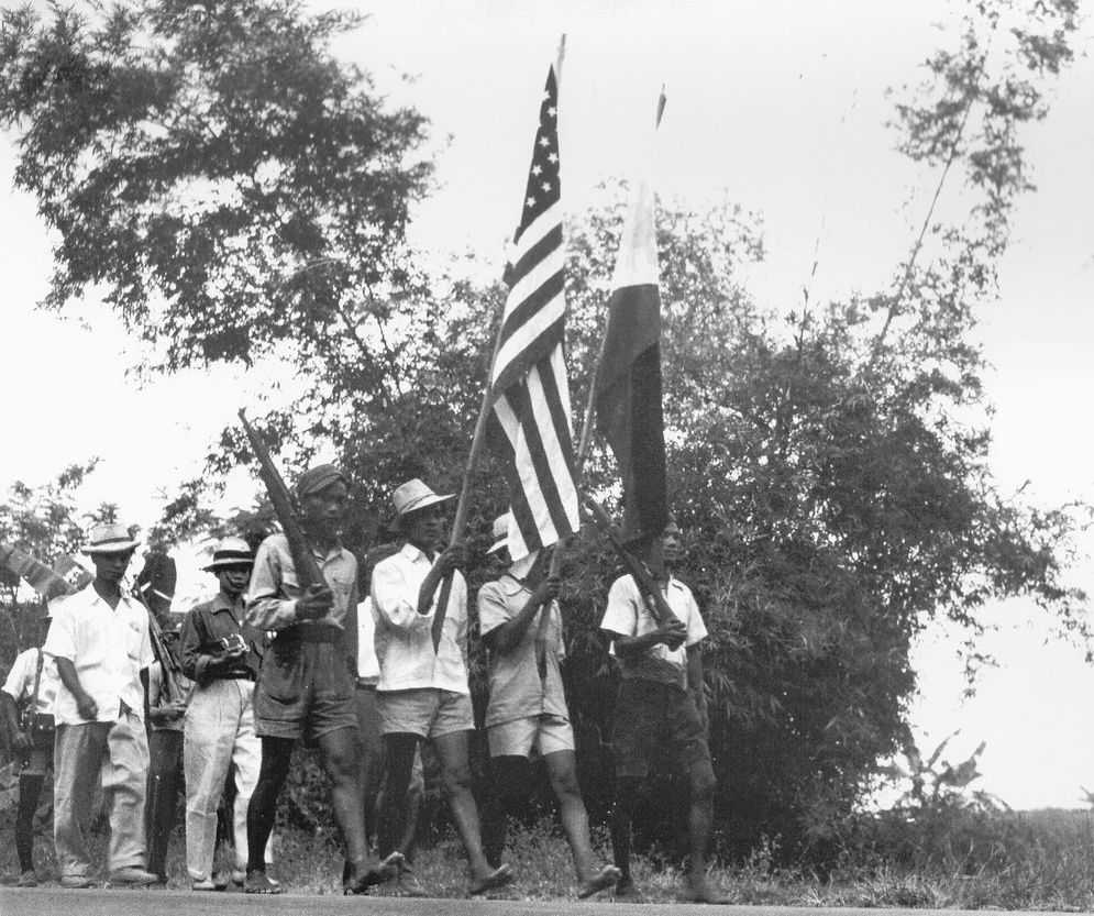Photo of Filipinos marching with the American and Philippine flags