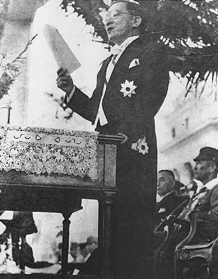 Photo of President José Laurel standing over podium reading and reciting a speech