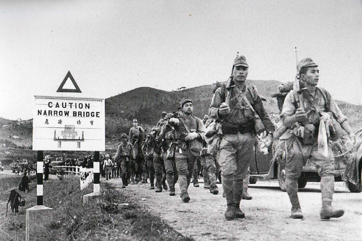 Photo of Japanese soldiers marching through a road