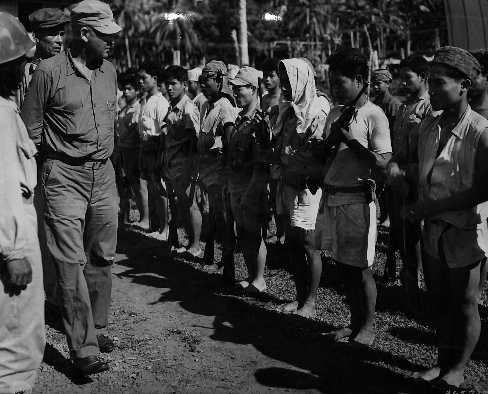 Photo of army general overseeing a line of guerrillas