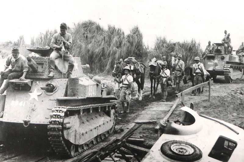 Image of soldiers on tanks rolling through jungle clearing