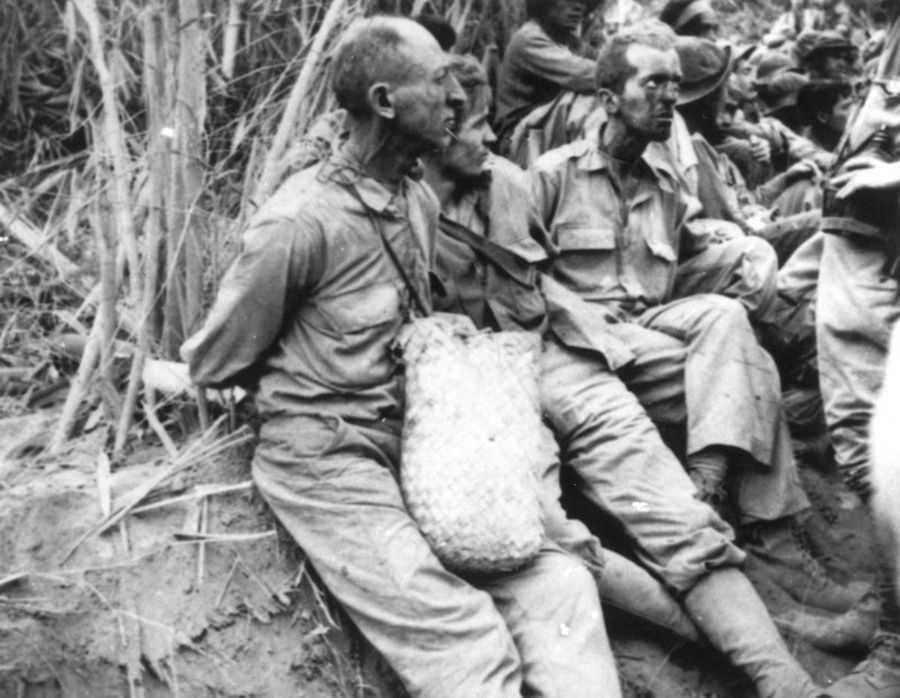 Photo of men sitting with hands bound behind their backs