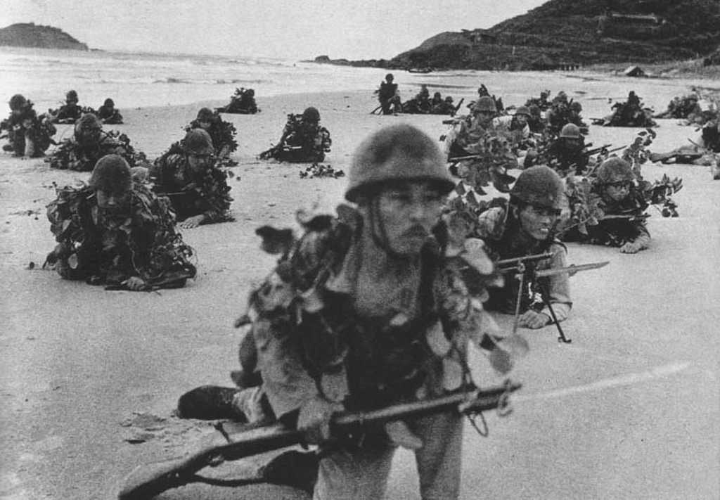 Photo of Japanese soldiers landing on beach, crawling with rifles