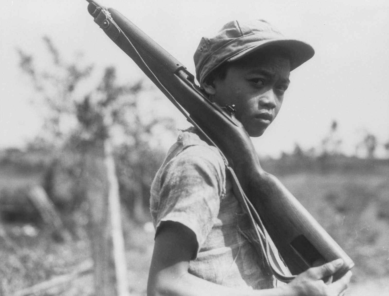 Photo of young boy holding a rifle over his shoulder