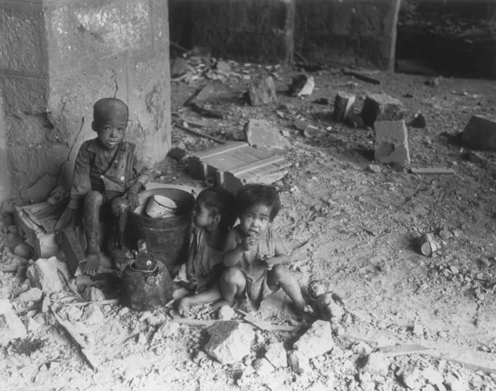 Photo of children sitting in rubble