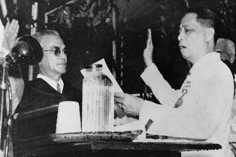Photo of President Manuel Roxas raising his right hand as he reads and recites in oath