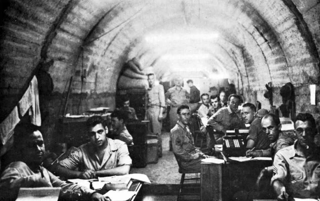 Photo of men sitting at various tables in a tunnel