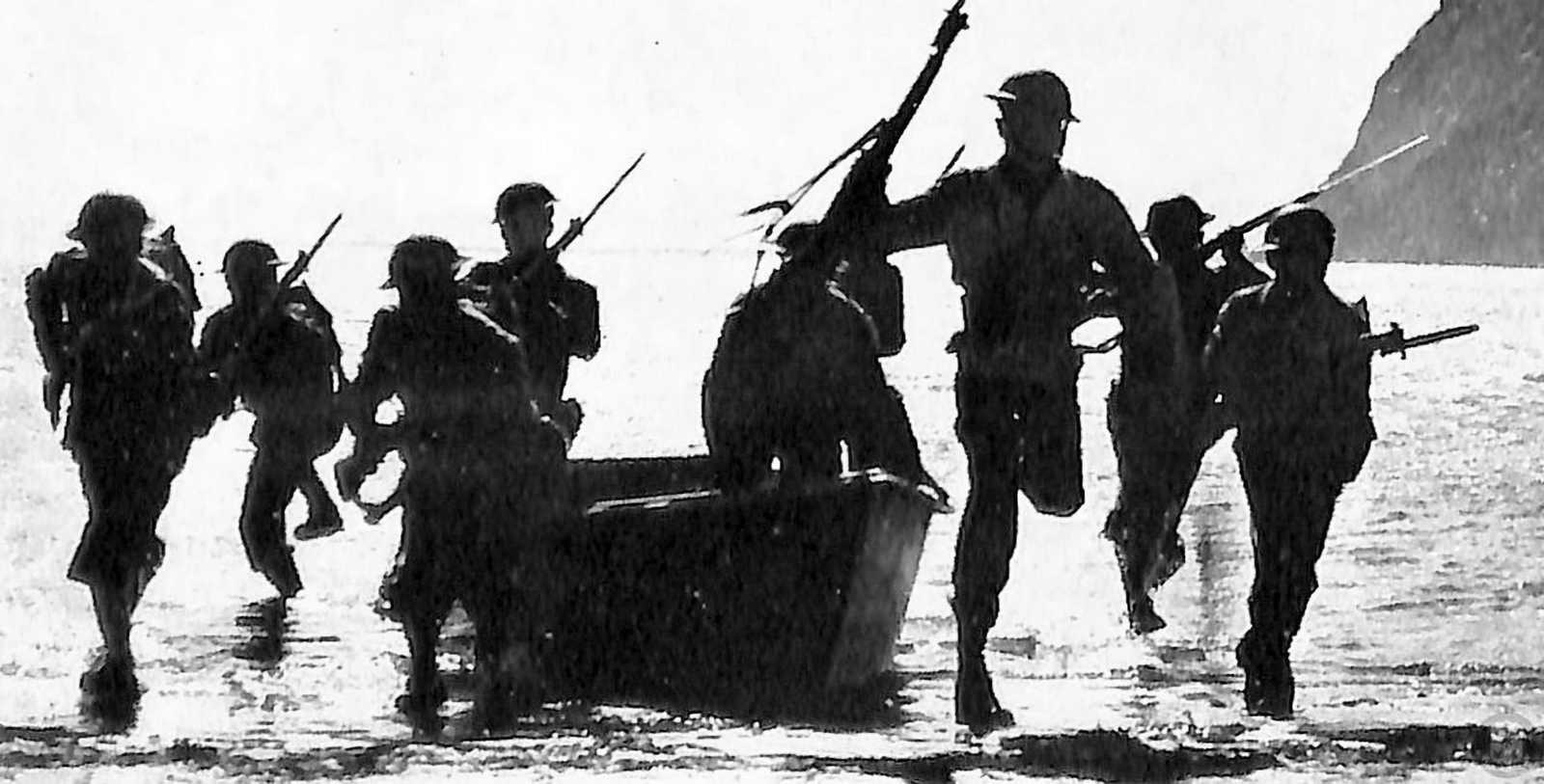 Photo of soldiers disembarking from a small landing craft, running with rifles up the shore onto the beach, silhouetted against the water and sky